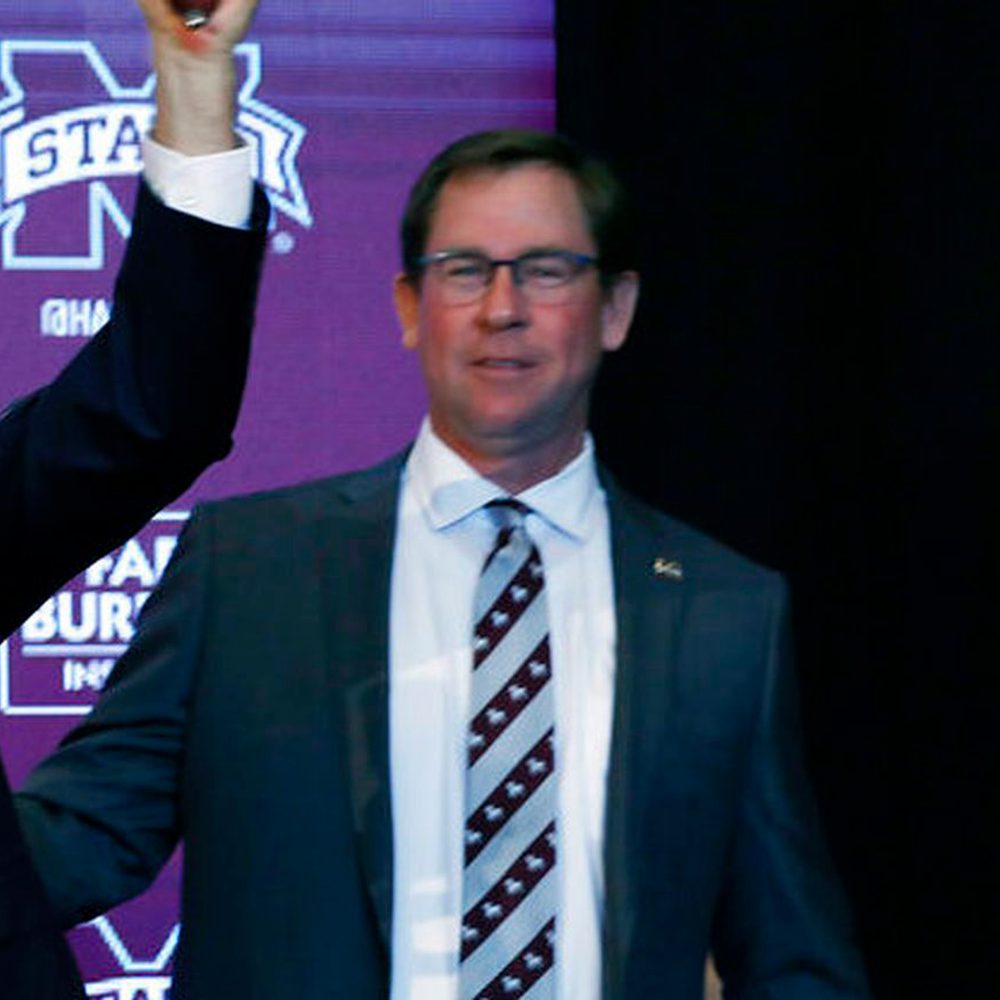 New Mississippi State football coach Mike Leach, center, stands between university president Mark Keenum, left, and athletic director John Cohen, as he rings the symbolic cowbell before reporters and school supporters, Friday, Jan. 10, 2020, at the Starkv Alabama News