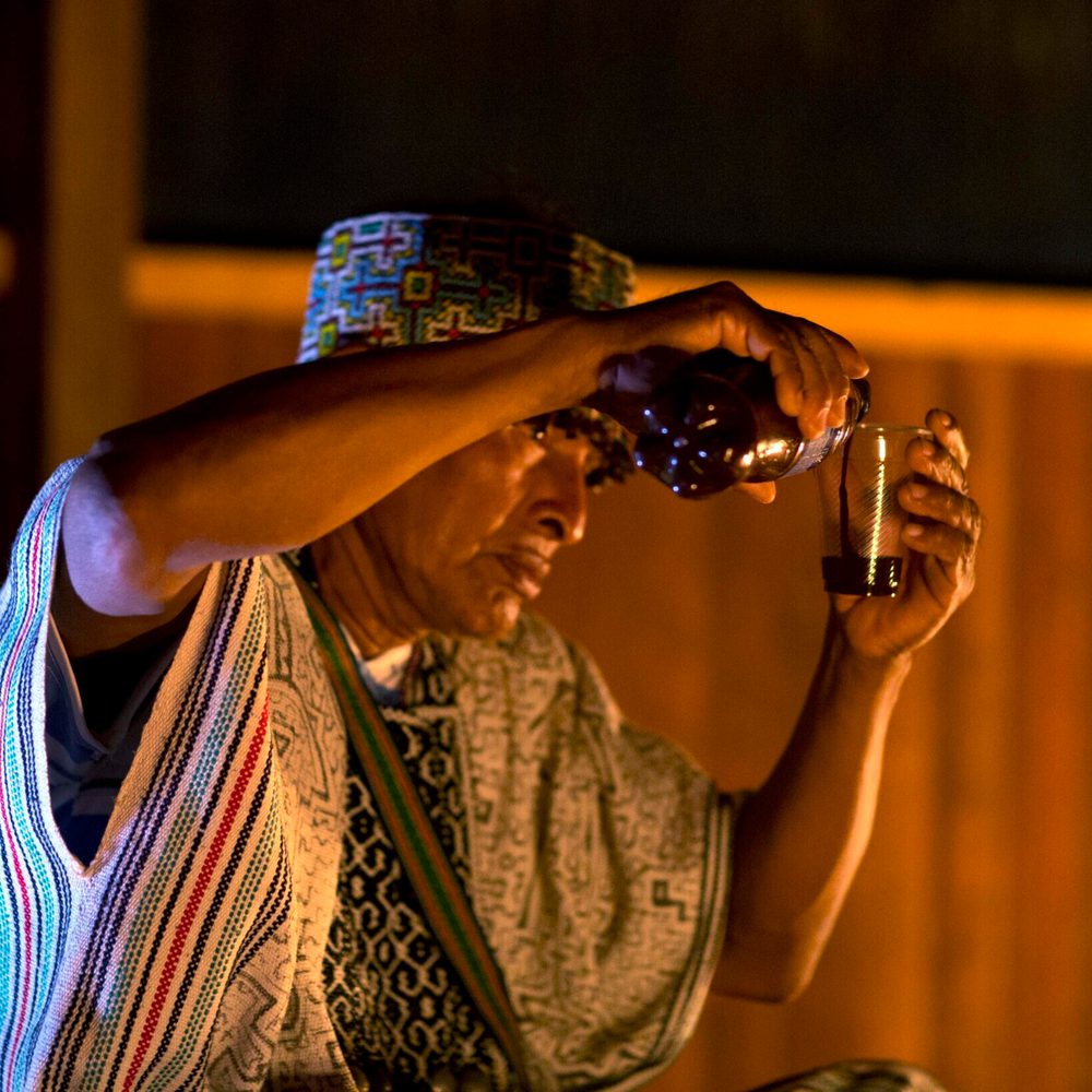 In this May 6, 2018, photo, Shaman Pablo Flores pours ayahuasca into a plastic cup during a session in Nuevo Egipto, a remote village in the Peruvian Jungle. Flores offers the ayahuasca it to Italian national Pamela Moronci, three ounces of a bitter, mudd Alabama News