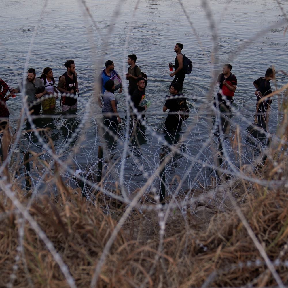 Migrants wait to climb over concertina wire after they crossed the Rio Grande and entered the U.S. from Mexico, Saturday, Sept. 23, 2023, in Eagle Pass, Texas. Alabama News