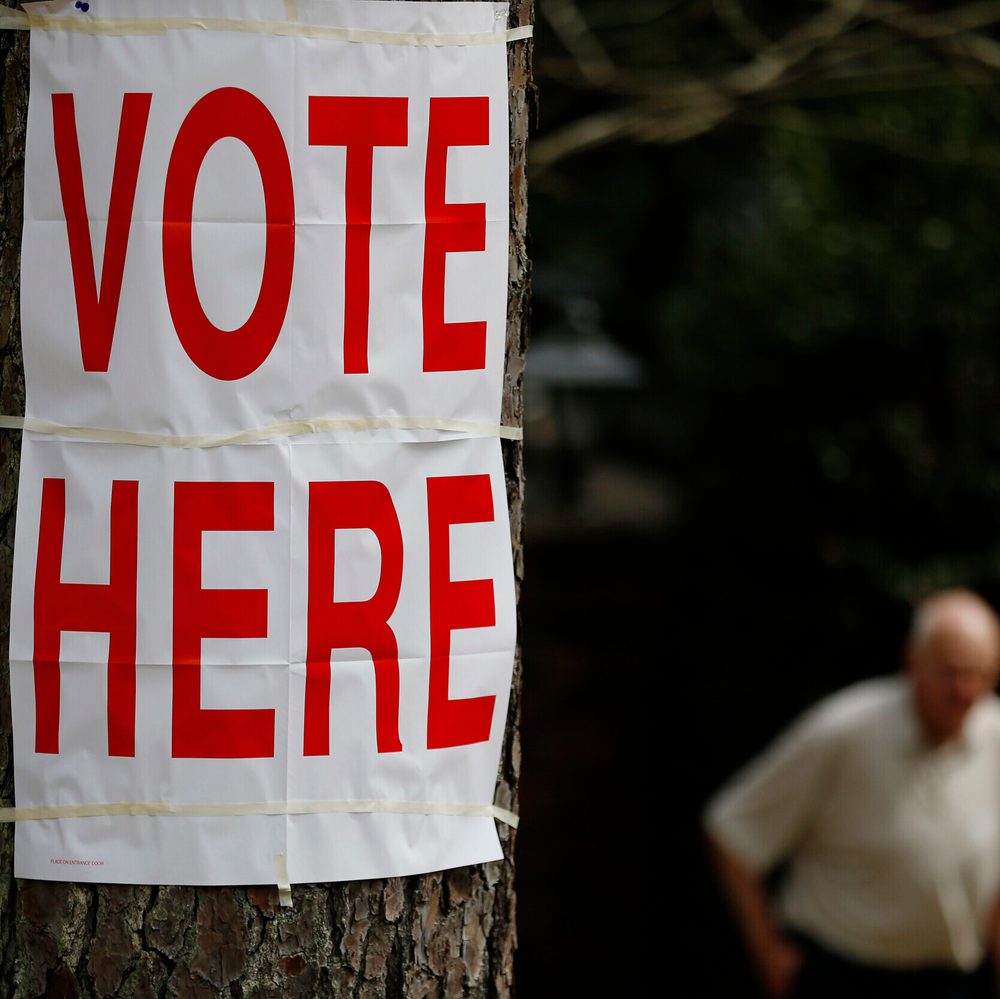 A voter walks by a "vote here" sign after he cast his ballot in Alabama's primary at a polling site, Tuesday, March 1, 2016, in Birmingham, Ala. Election Day, vote here Alabama News