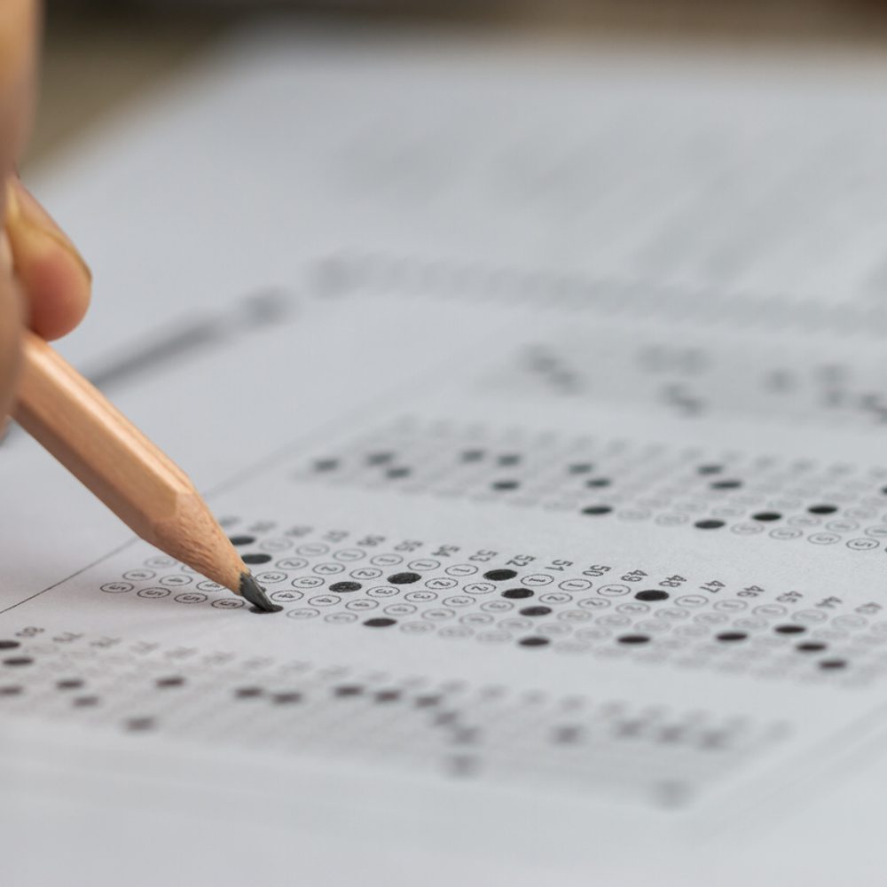 Education school test concept : Hands student holding pencil for testing exams writing answer sheet or exercise for taking fill in admission exam multiple carbon paper computer at university classroom stock photo Alabama News