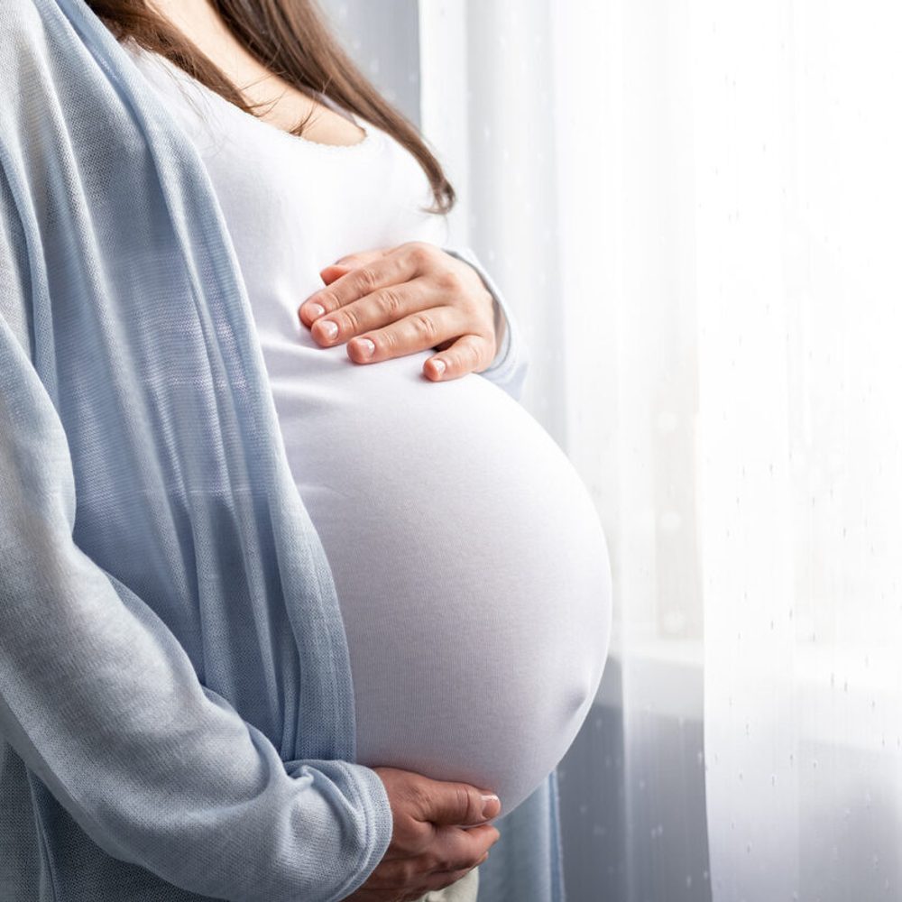 Healthy pregnancy. Side view pregnant woman with big belly advanced pregnancy in hands. Banner copyspace for text. Elegant mother waiting baby stock photo Alabama News