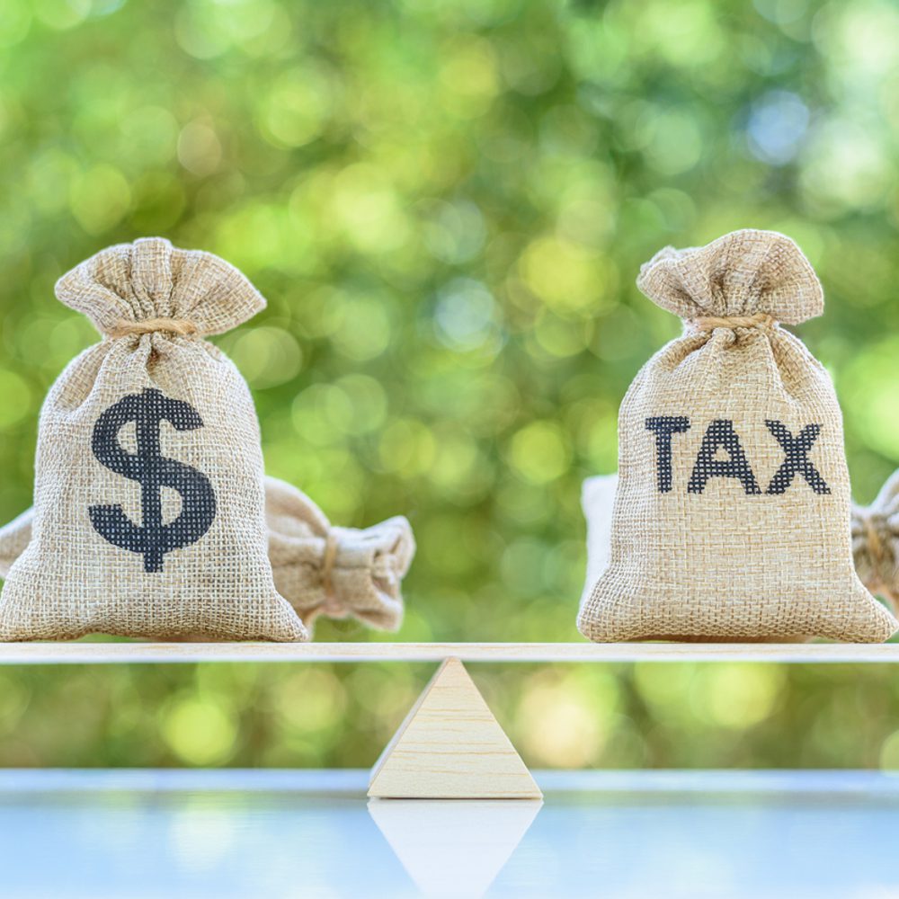 Tax, dollar money bags on a simple balance scale stock photo Alabama News