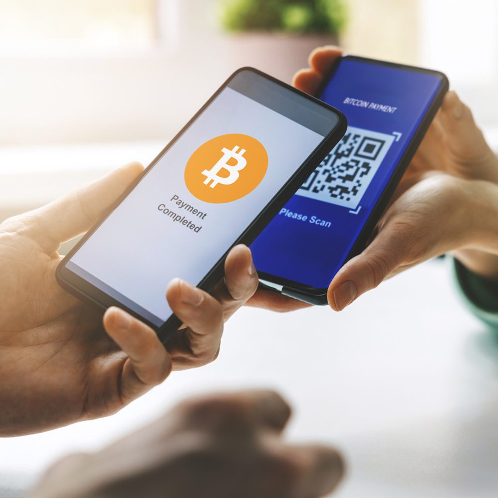 Bitcoin payment - person using smart phone to pay with crypro stock photoq Alabama News